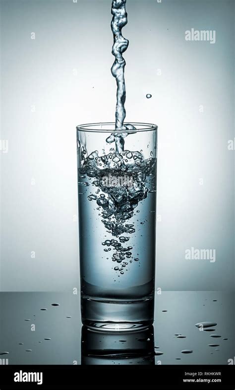 Water splashing from glass. Blue toned. Gradient background Stock Photo - Alamy