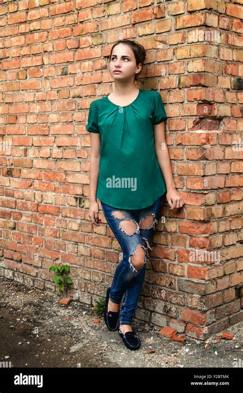 girl standing at a brick wall Stock Photo - Alamy