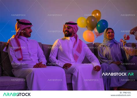 Gathering for a Saudi family on Eid, a Saudi Arab Gulf woman presenting Eid sweets, Eid among ...