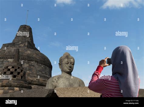 Tourist photographing Buddha statue on Temple of Borobudur, Borobudur ...