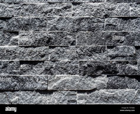 Close-up modern grey brick wall background. Grey stone brick tiles ...