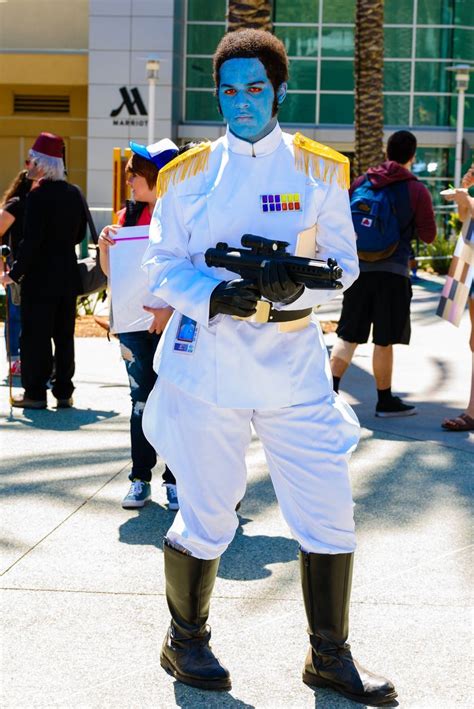 a man dressed in white and blue painted on his face is posing for the ...