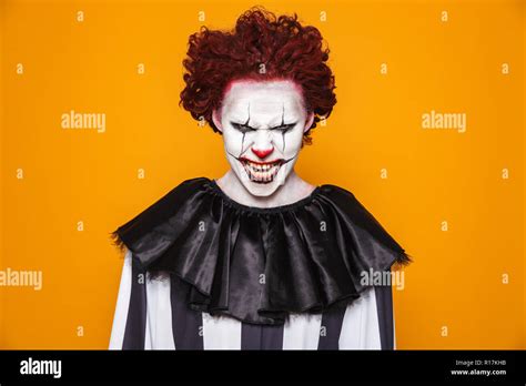 Tricky scary man clown in costume looking camera with anger and smiling ...