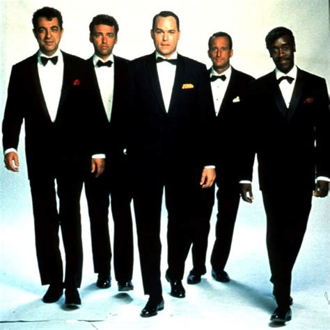 four men in tuxedos posing for a photo