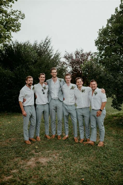 a group of men standing next to each other on top of a lush green field