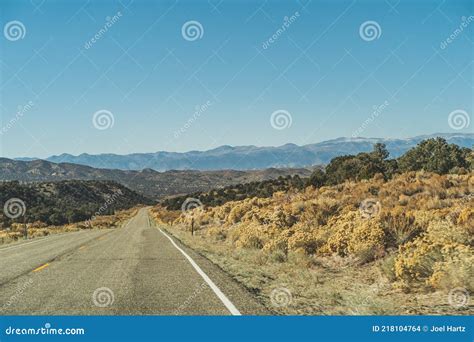 Two Lane Road in the Arid Sierra Nevada`s Leading To Mountains Against Blue Sky Stock Photo ...