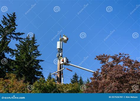 Two Linemen Working on a Wireless Communications Radio and Antenna Installation Using a Bucket ...