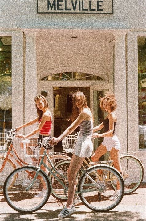 three women riding bikes in front of a store