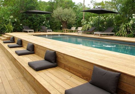 a wooden deck next to a swimming pool