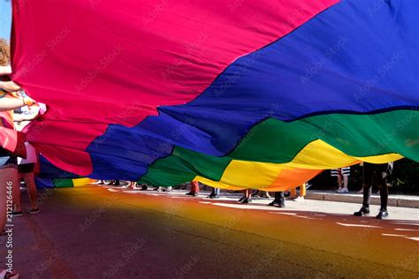 volunteers wawing a giant rainbow flag in a pride parade Stock Photo ...