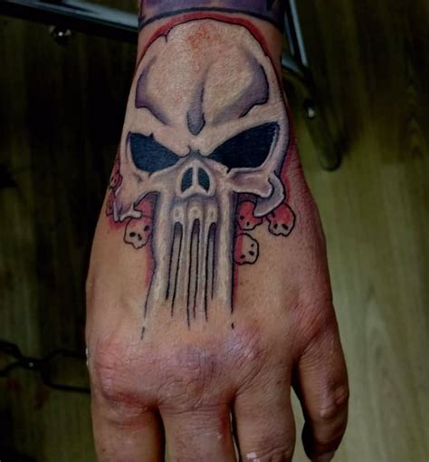 White and red punisher skull tattoo on upper hand