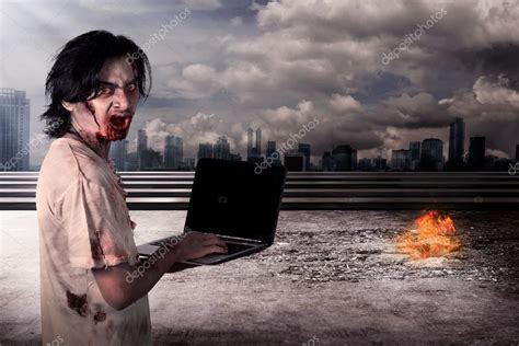 Creepy male zombie typing with laptop Stock Photo by ©leolintang 82824574