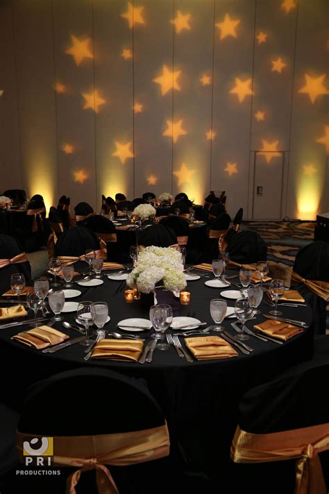 Custom star Gobo lighting projected on a wall during an awards ceremony. Black and gold color ...