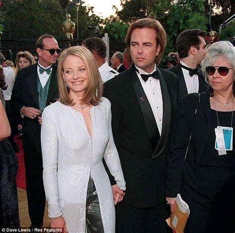 two people in tuxedos are walking down the red carpet at an awards event