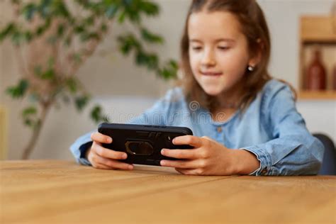 Happy Kid Girl Playing Game on Mobile Phone at Home Stock Image - Image ...