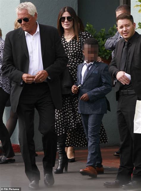 Sandra Bullock cuts a chic figure in a patterned dress as she enjoys lunch with her son Louis ...