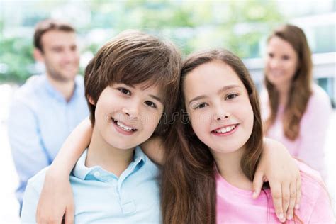 Children Smiling with Parents in Background Stock Image - Image of caucasian, husband: 55776583