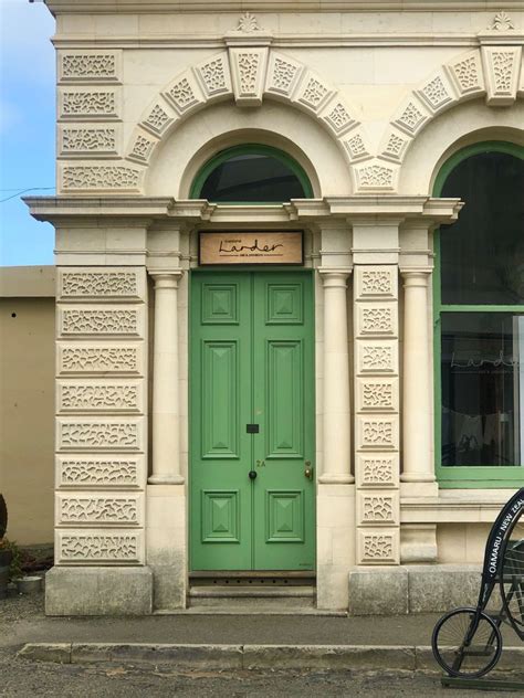 a bicycle parked in front of a green door on a building with arched ...