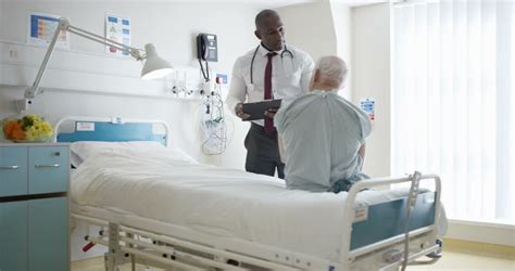 4K Friendly Hospital Doctor Examining Elderly Patient In A Private Room (UK-Oct 2016) Stock ...