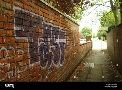 Graffiti tagging on red brick alleyway wall Cheltenham Gloucestershire England UK Europe Stock ...