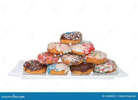 Many Cake Donuts Frosted And Covered In Candy Sprinkles Stacked On ...