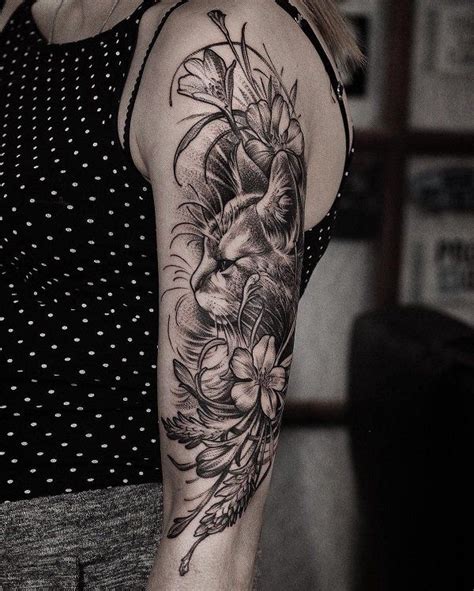 a woman's arm with flowers and a lion tattoo on the left side of her arm