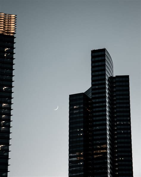 Modern skyscraper against night sky with moon · Free Stock Photo