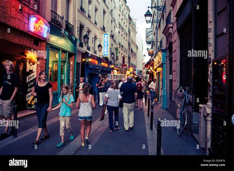 Latin district ( Quartier Latin ) Paris. Tourists walking by the ethnic restaurants at dusk in a ...