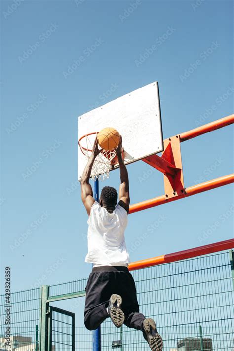 Basketball player in action and dunking Stock Photo | Adobe Stock