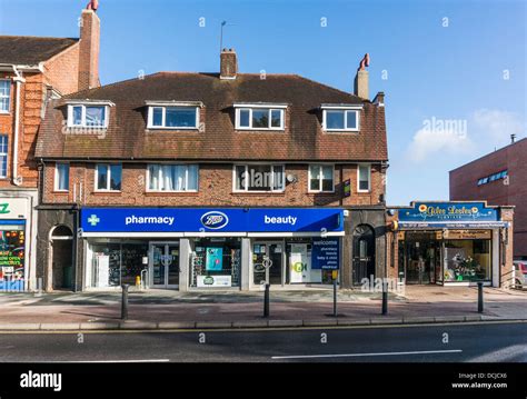 Local shops on Banstead village High Street (Boots and a florist), on a quiet Sunday morning in ...