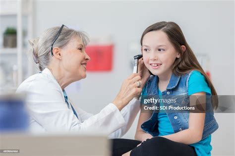 Confident Pediatrician Uses Otoscope To Check Young Patients Ear High ...