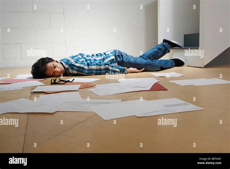 Young man lying on office floor Stock Photo - Alamy