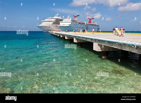 Cruise ship passengers on pier disembarking from Carnival cruise ships Triumph and Ecstasy in ...