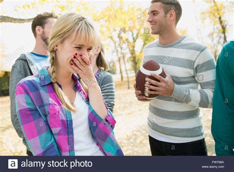 Young woman laughing with friends at park Stock Photo - Alamy