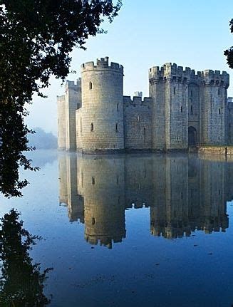 a castle sitting on top of a lake surrounded by trees