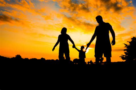 Parents Child Walking While Holding Hands In The Sunset Stock Photo - Download Image Now - iStock