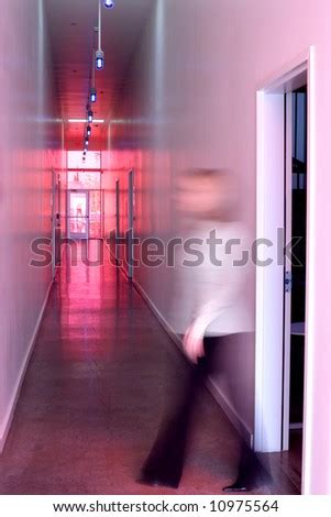 a business woman walks out the door and down the hall of a modern office - Stock Image - Everypixel