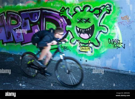 A cyclist passes graffiti in Glasgow city centre as the UK continues in lockdown to help curb ...