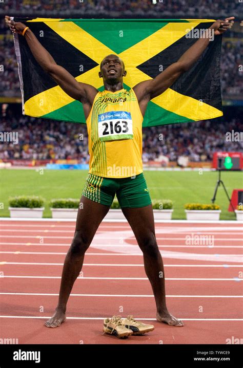 Jamaica's Usain Bolt jubilates with his country's flag after smashing ...