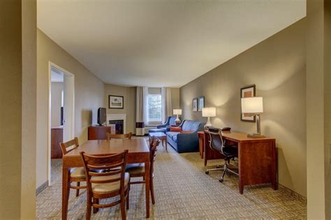 Table and chairs, desk, couch and seating area with fireplace