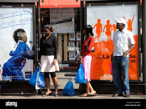 People standing at bus stop waiting Stock Photo - Alamy