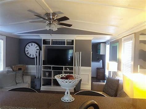 a living room filled with furniture and a flat screen tv mounted on a wall next to a window