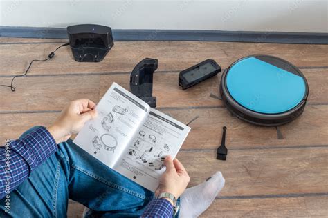 Reading the user guide for robot vacuum cleaner Stock Photo | Adobe Stock