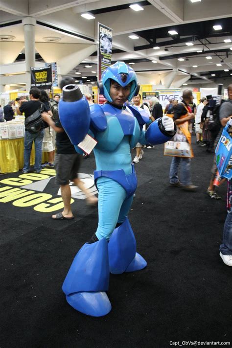 a person in a blue and white costume standing on a black carpet with other people around