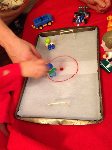 Make your own hockey rink at home! My husband drew the rink on paper and put it on a baking tray ...