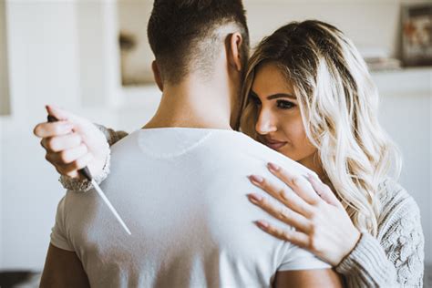 Couple Hugging While Shes Holding A Knife Behind His Back Stock Photo - Download Image Now - iStock