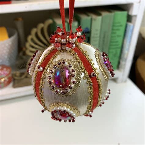 a christmas ornament hanging from a red ribbon on a white countertop in ...