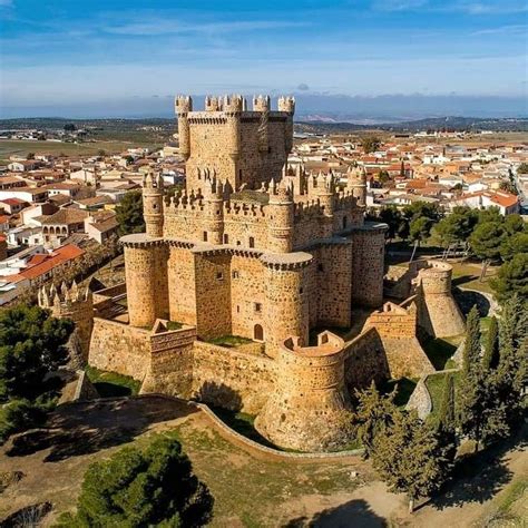 an aerial view of a castle with trees in the foreground