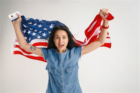 Free Photo | Young woman jumping with flag of the united states of america isolated on white studio.