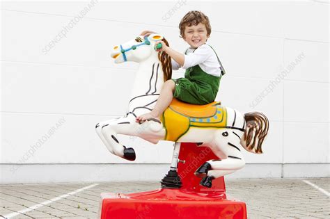 Boy riding mechanical horse outdoors - Stock Image - F004/5118 ...